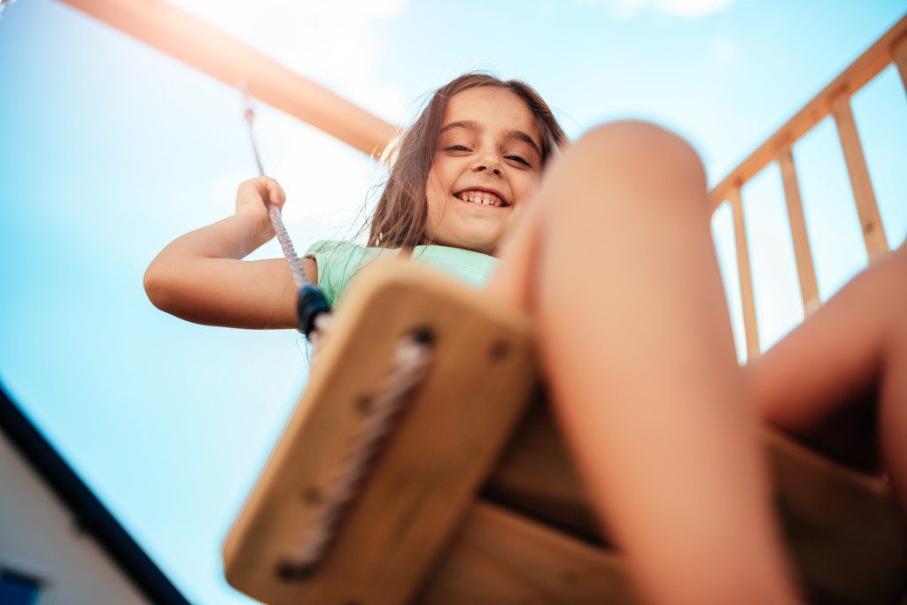 children having fun on a swing in a condominium playground