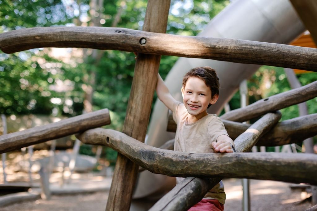 A child playing in a wooden playground